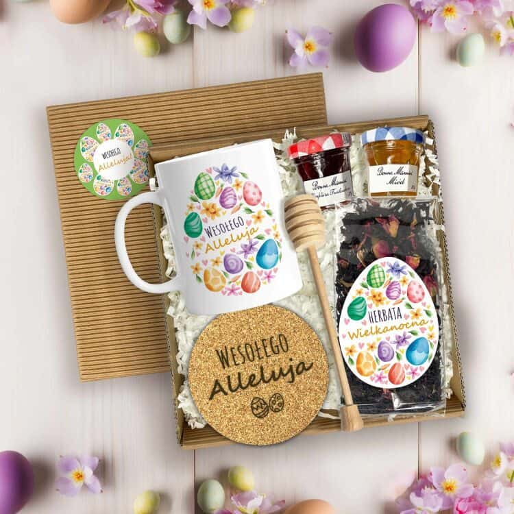 Otwarty box wielkanocny z kubkiem, herbatą, miodem, konfiturą i drewnianym miodownikiem na jasnym tle