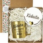 Zestaw w otwartym pudełku: złoty kubek i okrągła etykieta „Kobieta”