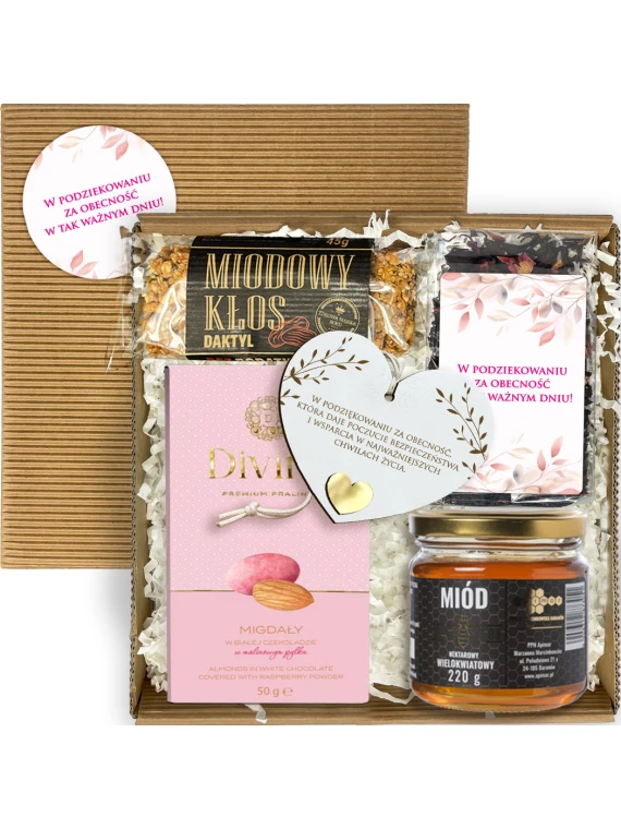 Otwarty box komunijny z herbatą, miodem, batonem, migdałami i zawieszką serce